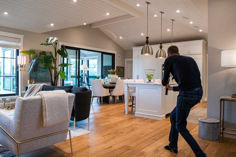 A real estate agent and couple review property documents at a kitchen table.