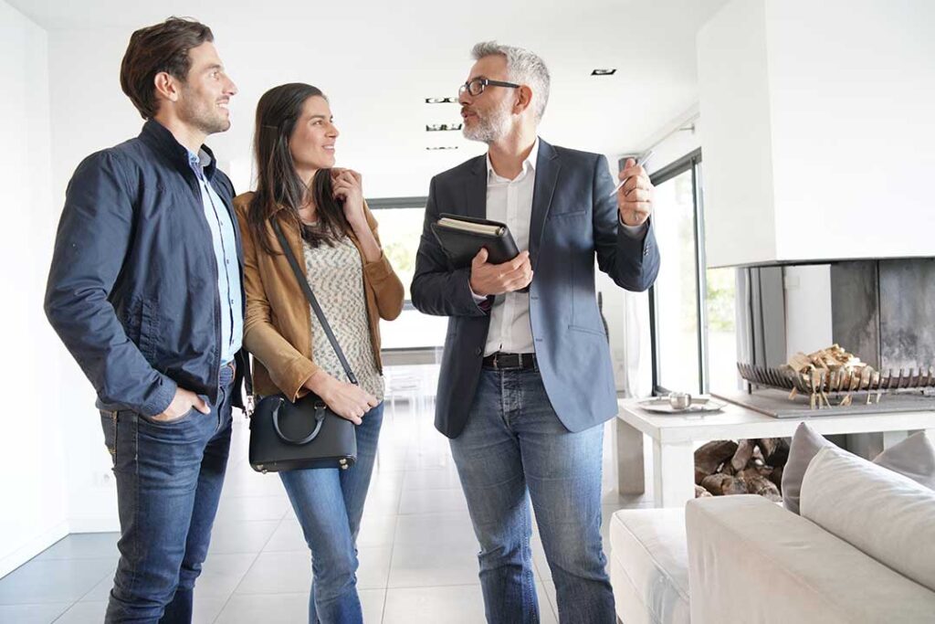 Appraiser measuring a home interior while reviewing property documents on a clipboard.